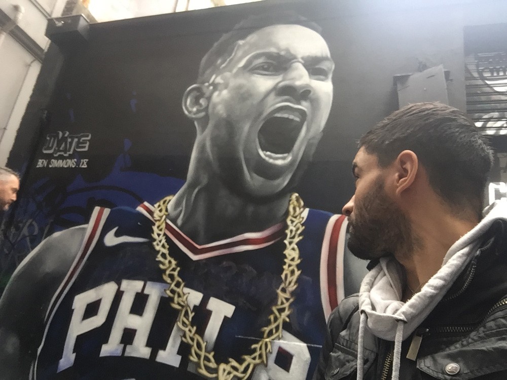 chico mirando de perfil a un jugador de la liga de baloncesto en una fotografía